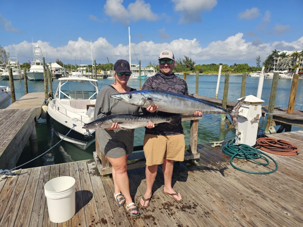 Two anglers displaying wahoo catches from deep sea fishing charter in Turks and Caicos